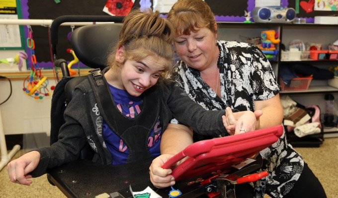 female student with physical disabilities working with assistive technology