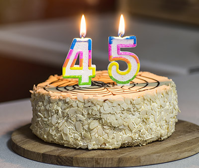 Birthday cake. Candles burn in the form of numbers 45.
