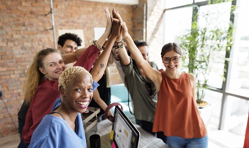 people group high five brick building collaboration teamwork open layout